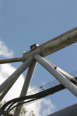 Çarpıcı bir metal yapı, arka planda canlı bir mavi gökyüzüne karşı gururla durur ve büyüleyici bir görsel karşıtlık yaratır.