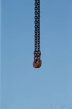 Uzun bir zincir berrak mavi gökyüzünde zarif bir şekilde sallanırken, parlak atmosferin güzel bir arka planı onu sarıyor.