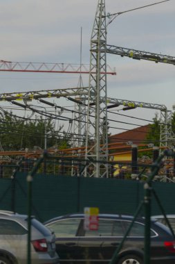 Şu anda inşaat ve yenileme çalışmaları devam etmekte olan bir binanın önünde park halindeki bir çok araba görülebiliyor.