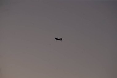 Küçük bir uçak zarif bir şekilde süzülüyor kayan gri bulutlarla dolu bulutlu bir gökyüzünde, kanatlarını ve tüm tasarımı gösteriyor.