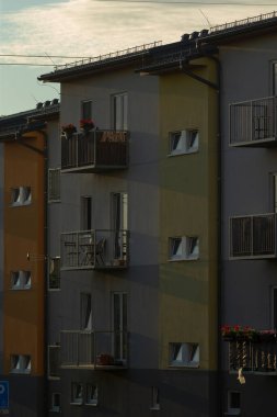 Çok sayıda balkon ve geniş pencereli, modern kentsel mimarinin sergilendiği ve yerleşim alanının geliştirildiği uzun bir sıra şık apartman.