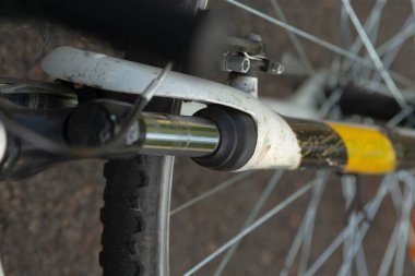 Bu resim, çerçevesi ve tasarımı boyunca uzanan belirgin sarı bir şeridi gösteren bir bisikletin ayrıntılı yakın plan görüntüsünü içerir.