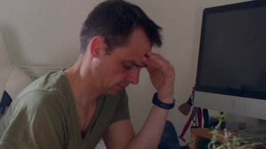 Bir adam kanepede oturur, kafası ellerde, umutsuzluğu ve duygusal karmaşayı yansıtır. Bu samimi tasvir onun sessiz mücadelesine bağlanmaya davet ediyor.