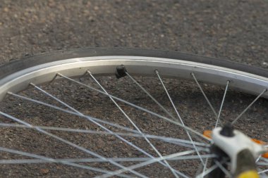 Bu, tekerlek ve tekerleğin karmaşık ayrıntılarını ve bileşenlerini gösteren bir bisiklet tekerleğinin yakın görüntüsü.