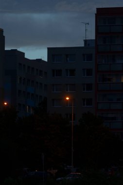 Gece parlak bir şehir ön planda parlayan bir sokak lambası arka planda görünen yüksek binalar, çarpıcı bir ufuk çizgisi yaratıyor.