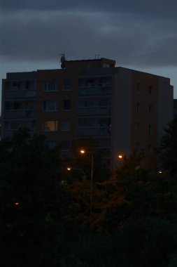 Gece saatlerinde büyük bir bina güzelce aydınlatılır. Önünde de bir sokak lambası bulunur.