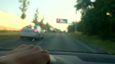 Bir insan gün batımında sıcak renklerle çevrili sakin bir otoyolda araba sürer. Huzurlu gökyüzü, huzur dolu atmosferine yansıma ve dalmaya davet ediyor.