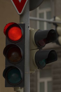 Şu anda kırmızı ışığı gösteren bir trafik ışığının detaylı bir yakın çekim görüntüsü, araçlara durmaları için işaret ediyor