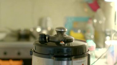 Mutfak tezgahında oturan bir düdüklü tencerenin detaylı yakın plan görüntüsü yemek pişirme alanında tasarım ve özelliklerini gözler önüne seriyor.