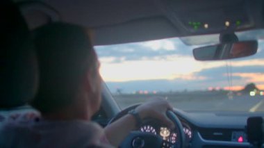 Bir adam gün batımına hayran bir şekilde otoyolda tek başına seyahat eder. Dikiz aynasında, gece çöktüğünde hayatını yansıtır, yıldızlı bir yolu ortaya çıkarır.