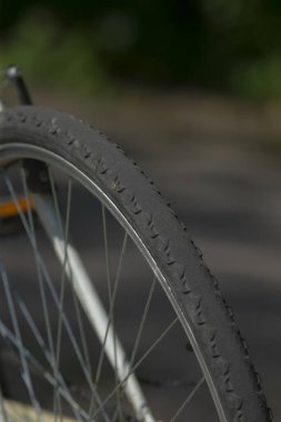 Bu, pürüzsüz bir yol yüzeyinde duran bisiklet lastiğinin detaylı bir yakın çekimi, karmaşık tasarımı ve özellikleri gözler önüne seriliyor.
