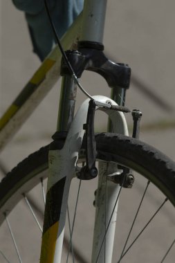 Sağlam siyah bir lastiğin yer aldığı, karmaşık tasarımı ve sağlam yapısını gözler önüne seren, işlevselliğini ve tarzını vurgulayan bir bisikletin ayrıntılı yakın çekimi.