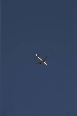 Bir uçak engin ve berrak mavi gökyüzünde zarif bir şekilde süzülüyor, havacılık ve hava yolculuğunun güzelliğini gösteriyor.