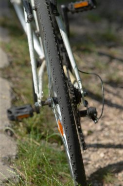 Bu, engebeli bir yolda duran bisiklet lastiğinin yakın çekim görüntüsü. Altındaki lastik ve yüzey detaylarını gösteriyor.