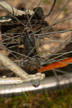 Yüzeyinde paslanma izleri gösteren, yıpranma ve yaşını vurgulayan bir bisiklet tekerleğinin detaylı yakın çekimi.