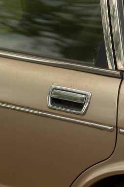 Bu, bir arabanın kapı kolunun detaylı bir yakın plan görüntüsü, karmaşık tasarım ve işçiliğini vurguluyor.