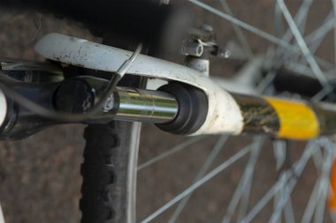 Bu, ön tekerleğin detaylarını ve tasarımlarını gösteren parlak sarı şeritli bir bisikletin karmaşık bir yakın çekim görüntüsü.