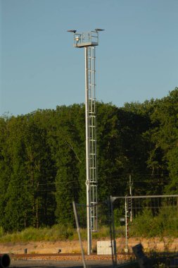 Erişim için tepesine sağlam bir merdiven yerleştirilmiş çok uzun metal bir kule.