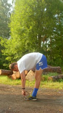Bu çekici video atletizm kıyafetleri içindeki bir adamı gösteriyor. Antrenman rutinini gösteriyor. İp atlama ve ayakkabı bağlama.
