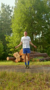 Huzurlu bir ormanlık alanda, bir adam doğayla bağlantı kurar, kütüklerin arkasında durur. Atlama halatıyla çevikliğini gösteriyor. Huzuru enerji hareketleriyle harmanlıyor.