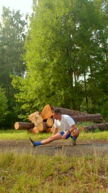 Bu video, doğada esneklik ve dayanıklılığı teşvik eden, sakin bir ormanlık alanda bacak esnetme ve çömelme hareketleri yapan bir adamı gösteriyor.