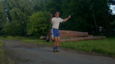 Bir adam parkta ip atlamak, koşmak, enerjik ruhunu ve doğa sevgisini sergilemek gibi aktivitelerle uğraşırken görülüyor.