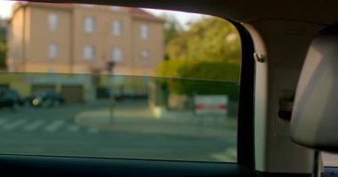 Bu video bir arabanın arka koltuğundaki kentsel yaşamı gösteriyor, bir binanın yakın planıyla başlıyor, sonra dinamik mimarinin panoramik görüntüleriyle başlıyor.