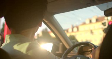 Canlı bir video, şık bir adam ve kadının gün batımında pitoresk bir şehirde araba sürüşünü, kendine güvenini ve macerasını gösteriyor.