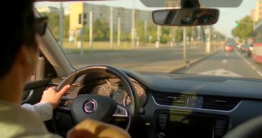 Bu videoda, bir adam hareketli bir şehir caddesinden geçiyor. Trafikte yol alırken canlı şehir manzarası dinamik bir zemin görevi görüyor.