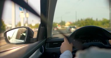 Bir adam sakin bir deneyim sergileyerek düz bir yolda araba sürer. Video, sürücülerin özgüvenini ve odaklanmasını vurgulayarak özgürlüğü yakalıyor.