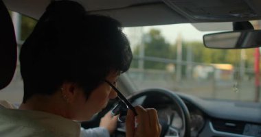 Bu videoda, kalabalık bir otoyolda ve şehir sokaklarında güvenle araba kullanan bir adamın arka planda şehir yaşamını somutlaştıran bir kadınla birlikte olduğu görülüyor.