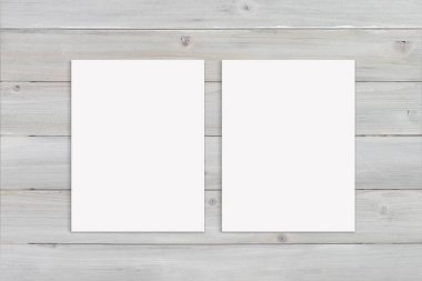 Kırsal modern gri ahşap arka planda tasarlanmış iki posterin yakın çekimi..