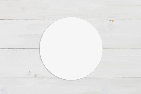 stock image Blank round sticker on display atop a contemporary white wooden background.