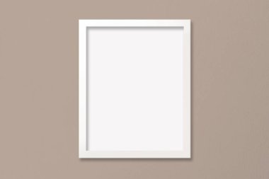 Modern bir bej duvarda asılı 11 'e 14 oranında beyaz çerçeve.