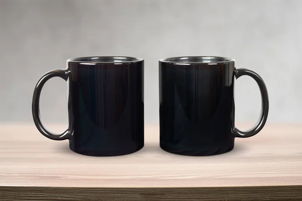 Närbild Två Svarta Kaffemuggar Avkopplande Ovanpå Ett Modernt Ljust Träbord — Stockfoto