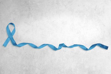 Beton arka planda kıvrık uçlu mavi kurdele fotoğrafı. Kopyalama alanı çok.