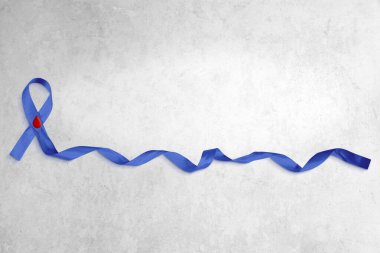 Beton arka planda kıvrık uçlu mavi kurdele fotoğrafı. Kopyalama alanı çok.