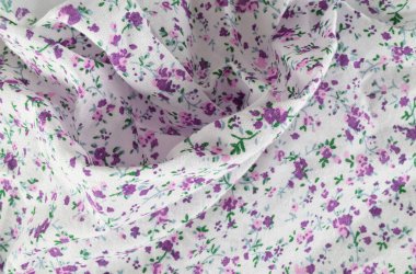 Beyaz kumaş arka planda mor çiçeklerin yakın çekimi. Arkaplan, pankart ve editoryal kullanım için ideal.