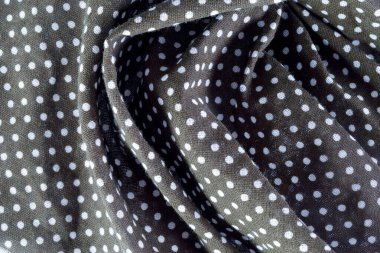 Kumaşın üzerindeki koyu gri polkadot kumaşına yakın plan. Arkaplan, pankart ve editoryal kullanım için ideal.