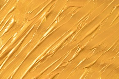 Kağıt üzerinde altın fırça darbelerinin yakın plan çekimi. Arkaplan, pankart ve editoryal kullanım için ideal.