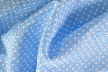 Mavi ve beyaz kumaş üzerine polkadot kumaş yakın çekim. Arkaplan, pankart ve editoryal kullanım için ideal.