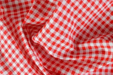 Close-up of abstract red checkered fabric in red and white. Ideal for backgrounds, banners, and editorial use.