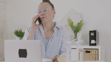 Female consultant is speaking on phone in front of pc
