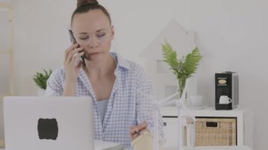 Female consultant is speaking on phone in front of pc