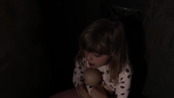 在黑暗的房间里拿着洋娃娃的害怕的女孩 高质量的4K镜头 — 图库视频影像