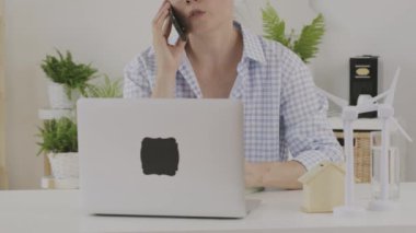 Female consultant is speaking on phone in front of pc