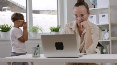 38 yıldır bilgisayarda çalışıyor. Arka planda çocuklar oynuyor