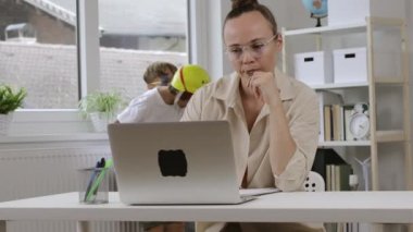 38 yıldır bilgisayarda çalışıyor. Arka planda çocuklar oynuyor