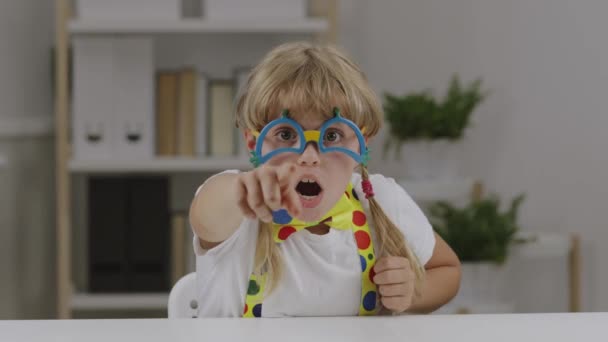 7年の面白い女の子はピエロの目の眼鏡 蝶やサスペンダーに身を包んだ 高品質4K映像 — ストック動画