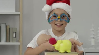 9 yıllık Noel Baba şapkalı çocuk oyuncak bebek besliyor. - Yakın çekim. Yüksek kalite 4k görüntü